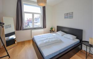 a bedroom with a bed with a large window at 1 Bedroom Amazing Apartment In Oostende in Ostend