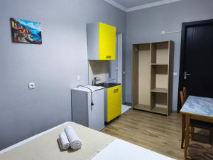 a small kitchen with a refrigerator and a table at Apartment Panorama in Tbilisi City