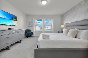 a bedroom with a large bed and a flat screen tv at Exceptional House 5BD4.5BA Private Pool WW8907 in Kissimmee +41 photos