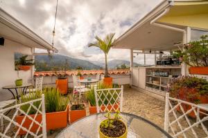 a patio with a table and chairs and a palm tree at Posada del Angel in Salento