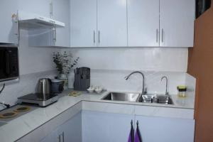 a kitchen with white cabinets and a sink at Modern House by EC Homes in Bangad