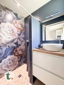 a bathroom with a mural of flowers on the wall at Tranquiloue - Maison de Campagne - PuyduFou in Treize-Vents