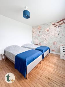 a bedroom with two beds and a map wall at Tranquiloue - Maison de Campagne - PuyduFou in Treize-Vents