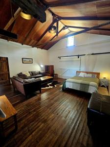 a bedroom with a bed and a couch and a desk at Barn on the Burnett, Mundubbera in Mundubbera +12 photos
