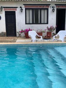 una villa con piscina di fronte a una casa di Casa San Sebastian, Hab baño compartido a Taganga