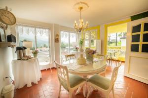 a dining room with a table and chairs and a clock at Posada del Angel in Salento