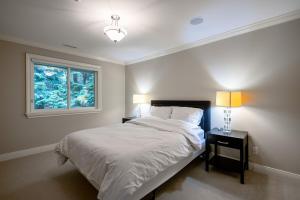 a bedroom with a large bed and a window at Luxury 5BR Villa, Gym, Theater & Ocean Views in West Vancouver +59 photos