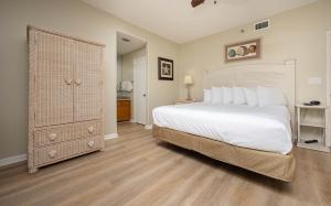 1 dormitorio con 1 cama blanca grande y armario en Phoenix East 1111 condo, en Orange Beach