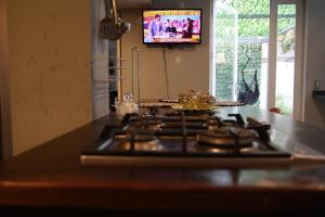 a stove top oven in a kitchen with a tv at Hostal Sueños De Lujo in Talca