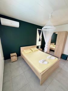 Un dormitorio con una cama y una pared verde. en Bung'hello Village, Piscine et Parking gratuit, en Trois-Rivières