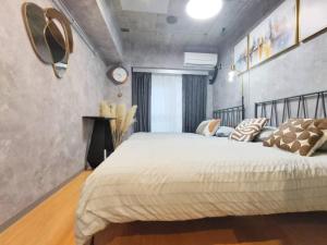 a bedroom with a large bed and a clock on the wall at PA Shinjuku St a-9mins -Higashishinjuku subway-5mins-新宿-步行伊势丹8分-MAX4p in Tokyo