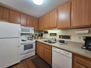 a kitchen with white appliances and wooden cabinets at Pinenut Place home in Incline Village