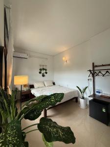 a bedroom with a bed and plants in it at Green homestay, King beds, 5min from Hue city in Thôn Trường Giang