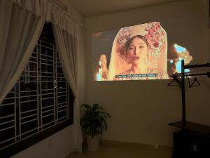 a large screen with a woman on a wall in a room at Green homestay, King beds, 5min from Hue city in Thôn Trường Giang