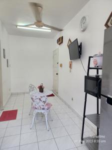 a room with a table and a chair and a tv at Dihome Ariel Twin Bed in Donggongon +1 photo
