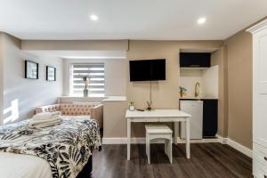 a bedroom with a bed and a desk and a kitchen at Lit Studio Spot Twin Beds,Amenities & Chill Vibes 1 in London