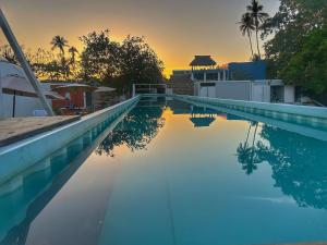 a swimming pool with a sunset in the background at Casa Nautilus barra de navidad in Barra de Navidad