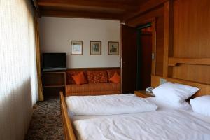 a hotel room with two beds and a television at Hotel Sonnleiten in Reit im Winkl