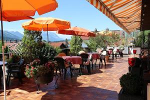 an outdoor patio with tables and chairs and umbrellas at Hotel Sonnleiten in Reit im Winkl