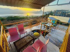 a balcony with chairs and a table and a sunset at Hotel Yogiraj in Jāmb