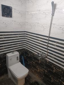 a bathroom with a toilet and a shower at Hotel Yogiraj in Jāmb