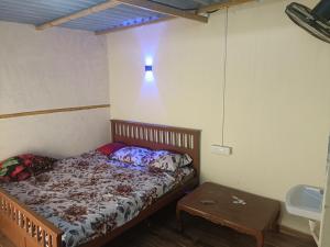 a small bedroom with a bed and a table at Hotel Yogiraj in Jāmb