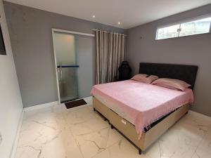 a bedroom with a bed with pink sheets and a window at Casa 2 Suítes Aluguel COP 30 Belém Pará in Belém