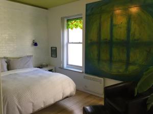 - une chambre avec un lit et une fenêtre ornée d'un tableau dans l'établissement Le 253, à Québec