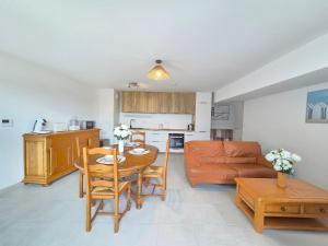 eine Küche und ein Wohnzimmer mit einem Tisch und einer Couch in der Unterkunft Appartement moderne avec terrasse proche mer et centre, Wi-Fi inclus à Saint-Brevin - FR-1-364-182 in Saint-Brevin-les-Pins
