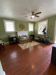 een woonkamer met een bank en een plafondventilator bij Cozy Cottage in Jacksonville