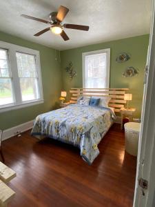 een slaapkamer met een bed en een plafondventilator bij Cozy Cottage in Jacksonville