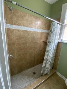 een douche met een douchegordijn in de badkamer bij Cozy Cottage in Jacksonville
