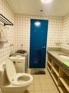 a bathroom with a toilet and a blue door at Torre De Manila taft Tan38 in Manila +11 photos
