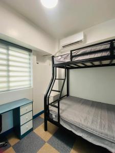 a room with two bunk beds and a desk at Torre De Manila taft Tan38 in Manila