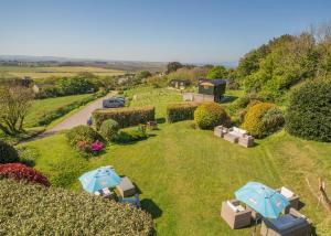圣阿格尼丝Beacon Shepherd Huts的花园的空中景致,配有遮阳伞