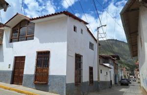 a white building on the side of a street at Caraz Miski Wuasi in Caraz