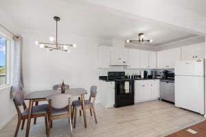 a kitchen with white cabinets and a table and chairs at Relaxing 2-Bedroom Oasis in Pacifica in Pacifica