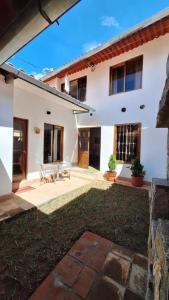 a white house with a patio and a yard at Caraz Miski Wuasi in Caraz +12 photos