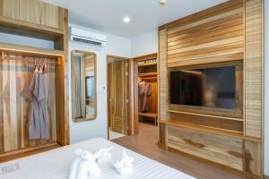 Schlafzimmer mit einem Bett, einem TV und einem Schrank in der Unterkunft Phi Phi at Pier in Ko Phi Phi