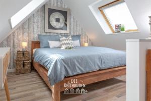 una camera da letto con un letto con un piumone blu di Bude-2 a Büsum