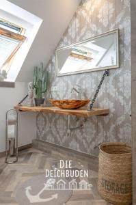 un bagno con un lavandino e uno specchio su una parete di Bude-2 a Büsum Altre 20 foto