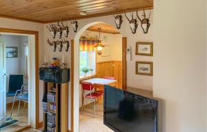 a living room with a television and a dining room at Beautiful Home In Torsås With Kitchen in Torsås