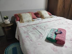 a bed with blankets and pillows on it at Pousada Canto dos pássaros in Cianorte