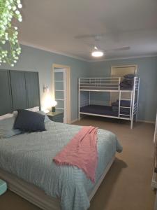 a bedroom with a bed and two bunk beds at Temoca Cottage Echuca Central in Echuca +43 photos