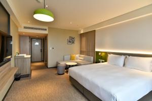una camera d'albergo con un letto grande e un divano di Holiday Inn Taoyuan Airport by IHG a Dayuan Altre 37 foto
