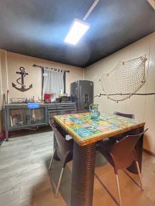 a dining room with a table with chairs and a kitchen at Casa Garfio in Barra de Navidad