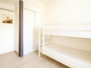 une chambre avec des lits superposés et un miroir dans l'établissement Pavillon climatisé, proche plages et village, terrasse, parking, animaux admis - Argelès-sur-Mer - FR-1-732-4, à Argelès-sur-Mer 9 autres photos