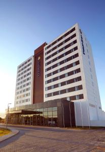 un grand bâtiment avec une horloge sur son côté dans l'établissement Tulip Inn Itaguai, à Itaguaí