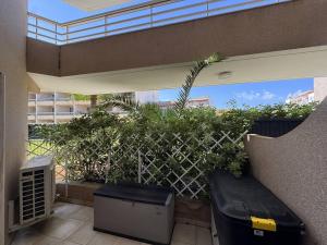 a patio with a fence and a bench and plants at Appartement avec grande terrasse et garage à Cavalaire-sur-Mer - FR-1-100-355 in Cavalaire-sur-Mer