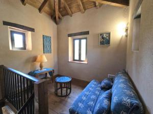 a living room with a blue couch in a room at Gîte 8 personnes avec cheminée et SPA à Biron - FR-1-616-481 in Biron